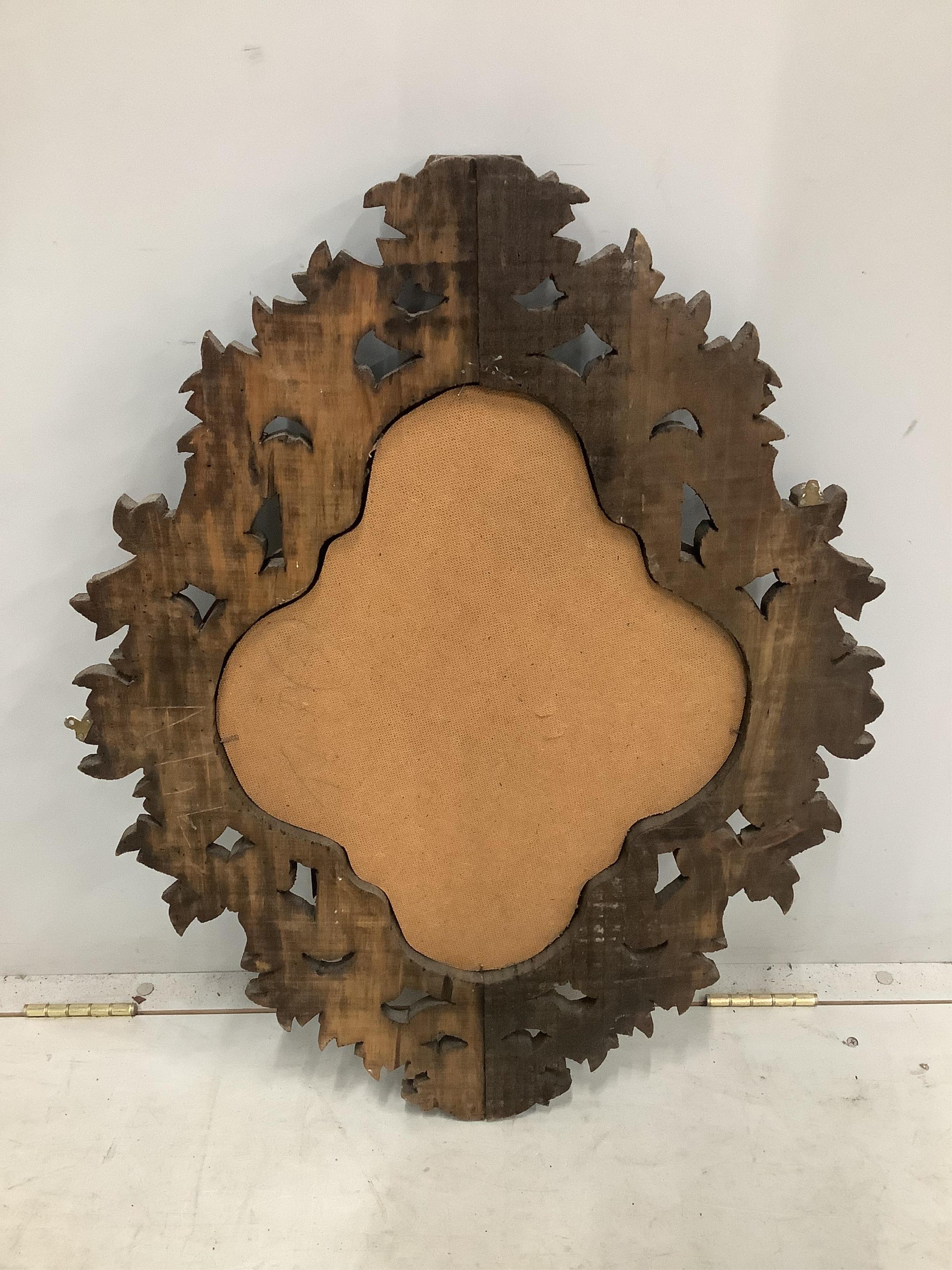 An 18th century style shaped oval carved pine wall mirror, width 61cm, height 79cm. Condition - fair